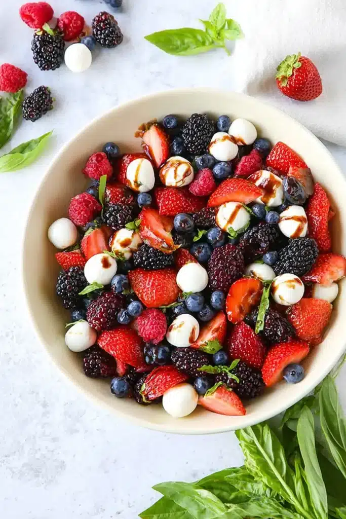 Close up Berry Caprese Salad with berries, mozzarella, basil, and balsamic drizzle