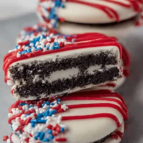 Oreos dipped in white chocolate with patriotic sprinkles