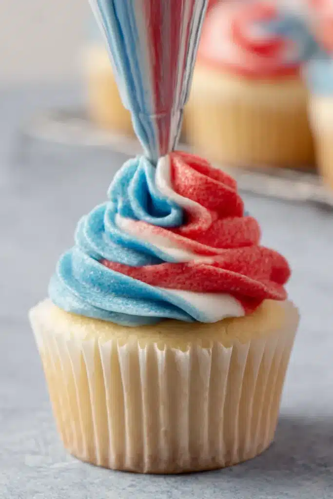 Patriotic Cupcakes 5 Patriotic Cupcakes with red white and blue frosting being piped