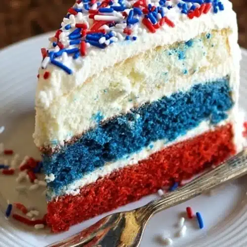 Red White and Blue Cheesecake Cake 4 Red White and Blue Cheesecake Cake slice with cream cheese frosting and patriotic sprinkles