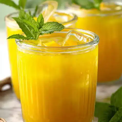 Refreshing Homemade Mango Lemonade with mint and ice in glass jars