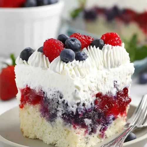Summer Berry Poke Cake with berries and creamy whipped topping