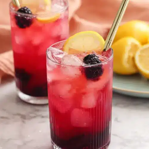 Blackberry Lemonade 3 Blackberry Lemonade with fresh lemon slices, blackberries, and ice in tall glasses