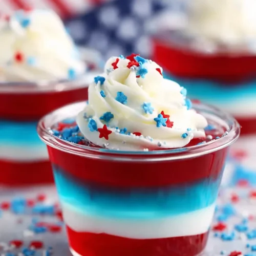 Bomb Pop Jello Shots with red white and blue layers and whipped cream