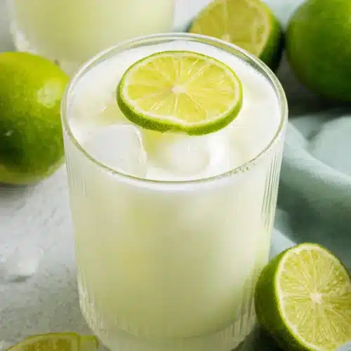 Brazilian Lemonade with lime slices and ice in a creamy citrus drink