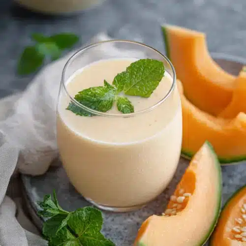 Cantaloupe Smoothie Recipe 5 Creamy cantaloupe smoothie with mint garnish in a glass