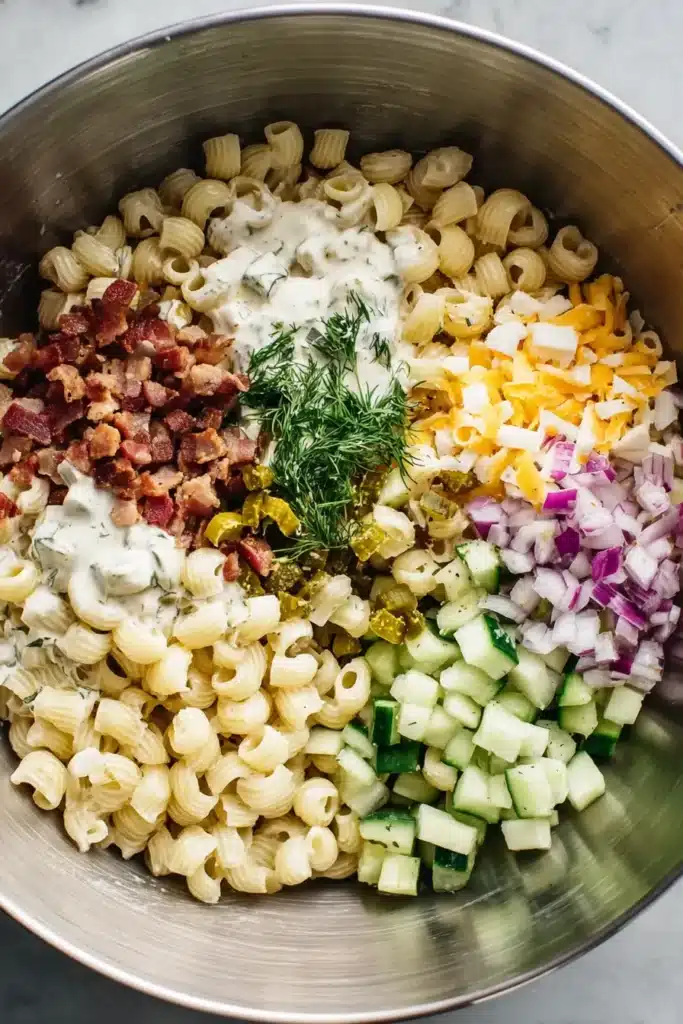 Dill Pickle Bacon Pasta Salad 3 Dill Pickle Bacon Pasta Salad ingredients combined in a mixing bowl before tossing