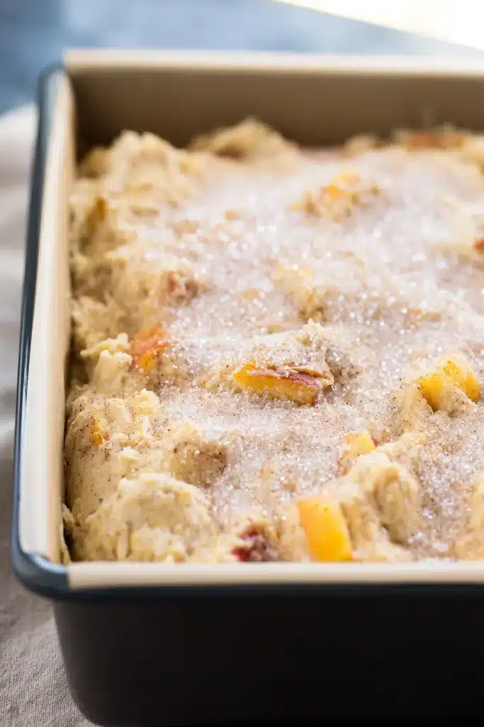 Easy Spiced Peach Bread batter in loaf pan with sparkling sugar topping