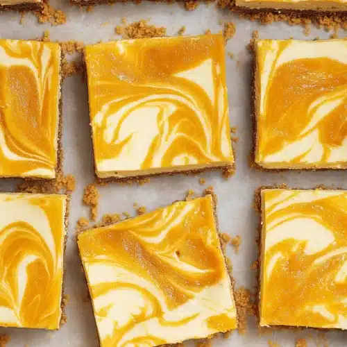 Mango Cheesecake Bars 5 Mango Cheesecake Bars sliced into squares with creamy mango swirl topping