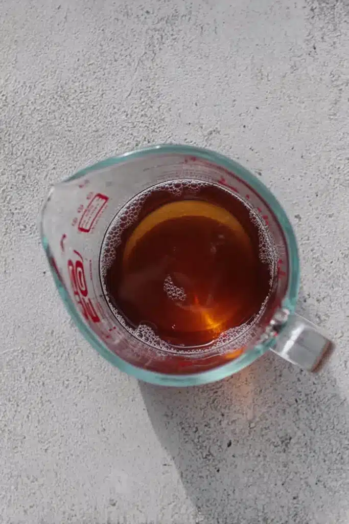 Refreshing Apple Iced Tea cooling in a glass measuring cup before serving