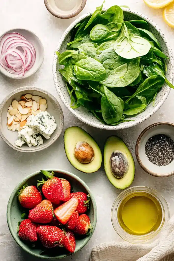 Strawberry Avocado Spinach Salad 1 Strawberry Avocado Spinach Salad ingredients with spinach, strawberries, avocado, almonds, and cheese