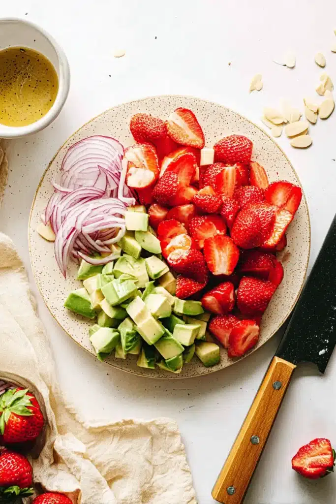 Strawberry Avocado Spinach Salad 2 Prepared Strawberry Avocado Spinach Salad ingredients with sliced strawberries, avocado, and red onion