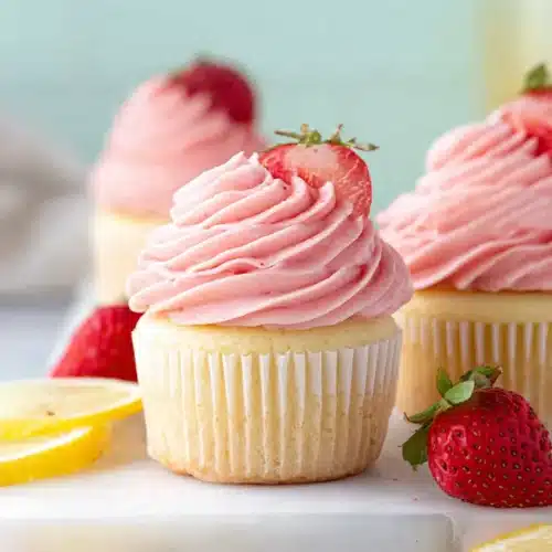 Strawberry lemonade cupcakes with pink strawberry frosting and fresh lemon slices
