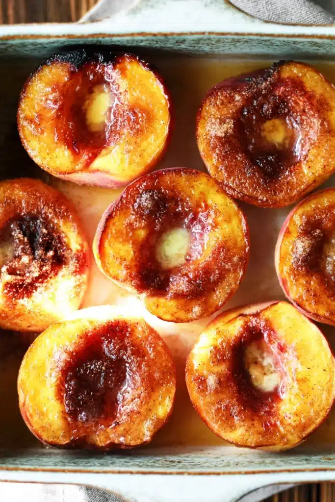 Cinnamon sugar baked peaches in baking dish with caramelized tops