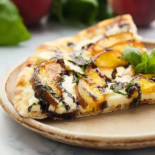 Peach and basil naan bread pizza slice with mozzarella and balsamic glaze on a plate